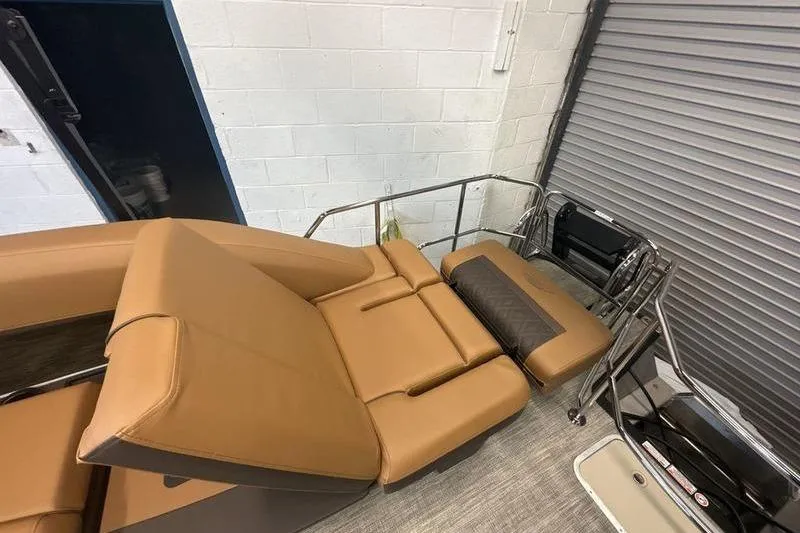 Slide: The Image of 2026 Bennington 24 MSL boat interior with tan seating and metal railings. - 2