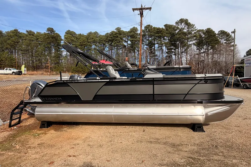 Slide: The Image of 2026 Veranda VR 235 VL pontoon boat parked outdoors, surrounded by trees and fencing. - 3