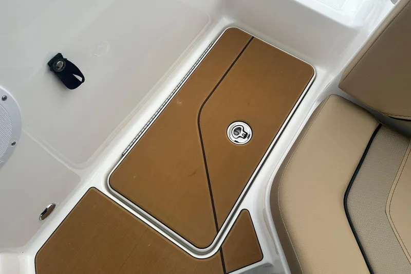 Slide: The Image of 2026 Bayliner V20 boat interior with tan seating and storage compartment. - 23