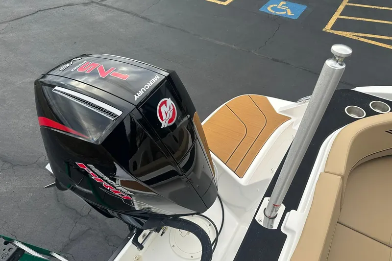 Slide: The Image of 2026 Bayliner V20 boat with Mercury outboard motor, docked in a parking area. - 24