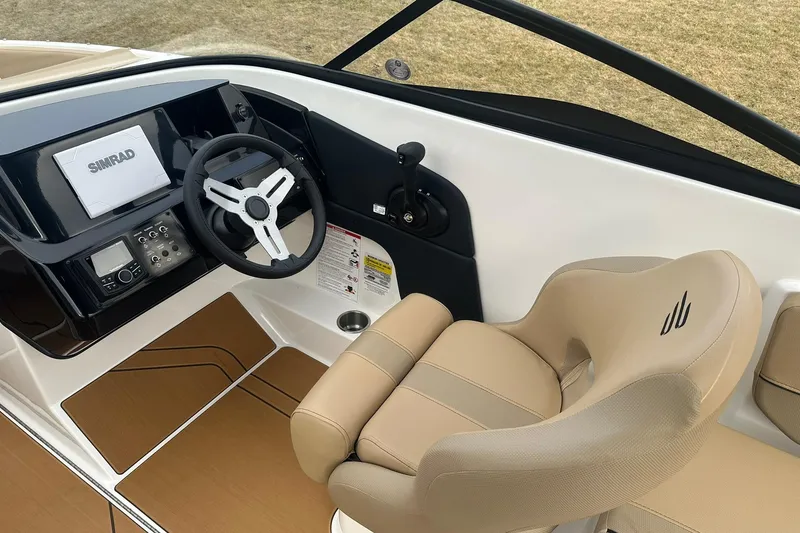 Slide: The Image of 2026 Bayliner V20 boat cockpit with steering wheel, Simrad display, and beige seating. - 9