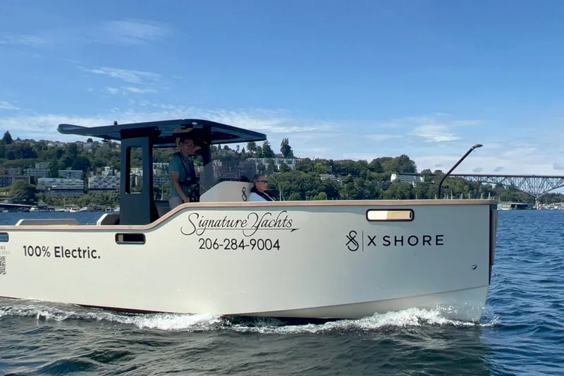 The Image of 2023 X Shore Eelex 8000 electric boat cruising on a scenic waterway. - 0