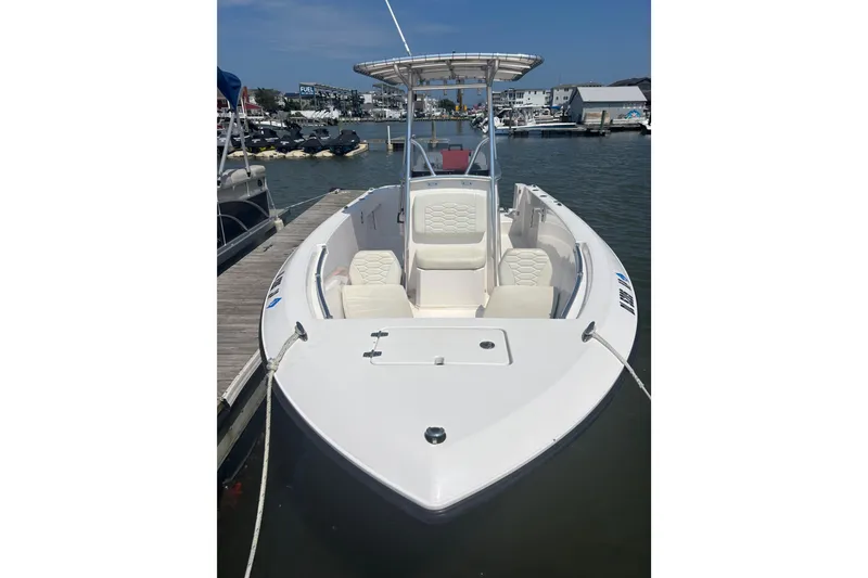 Slide: The Image of 2024 Aquasport 2200 Center Console boat docked at marina, featuring sleek design. - 3