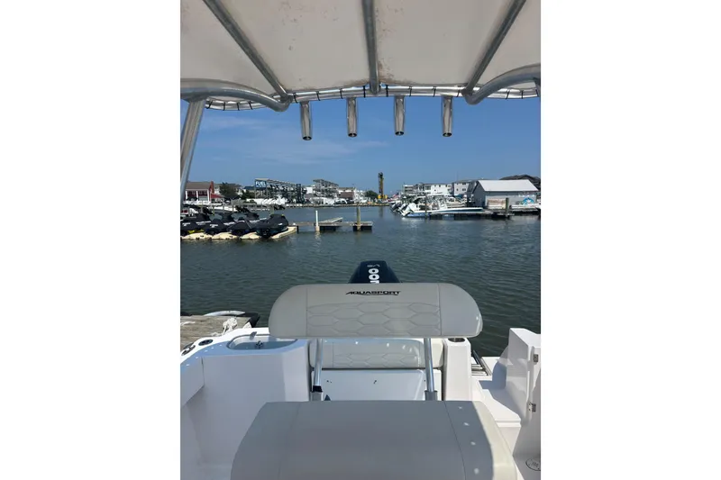 Slide: The Image of 2024 Aquasport 2200 Center Console boat docked in a scenic marina. - 4