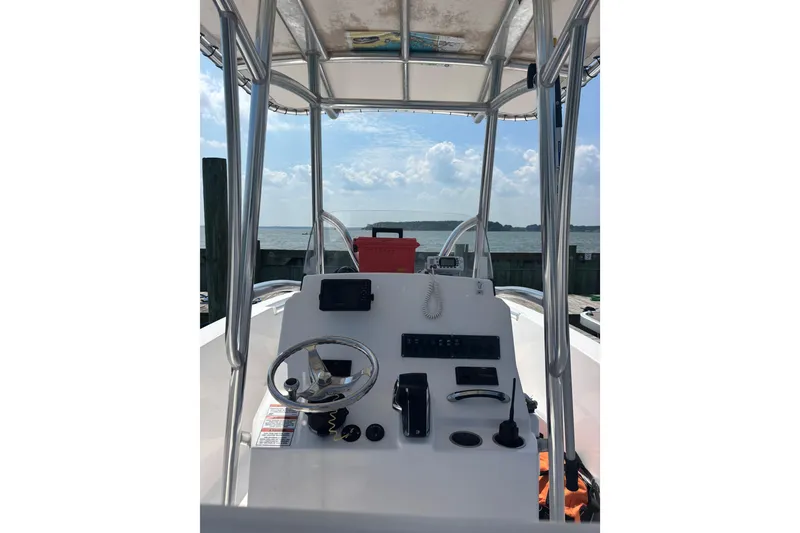 Slide: The Image of 2024 Aquasport 2200 Center Console boat interior with steering wheel and controls. - 5