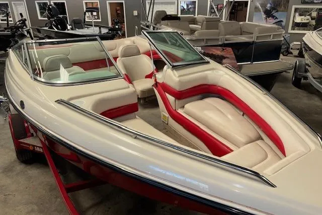 Slide: The Image of 1995 Crownline 180 BR boat with red and beige interior, displayed indoors. - 11