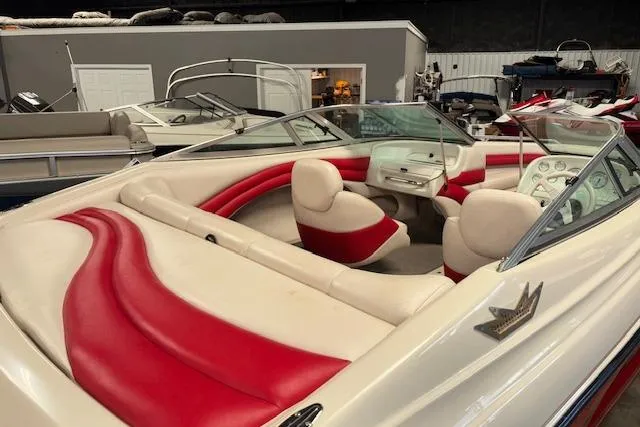 Slide: The Image of 1995 Crownline 180 BR boat interior with red and white seating in a showroom. - 12