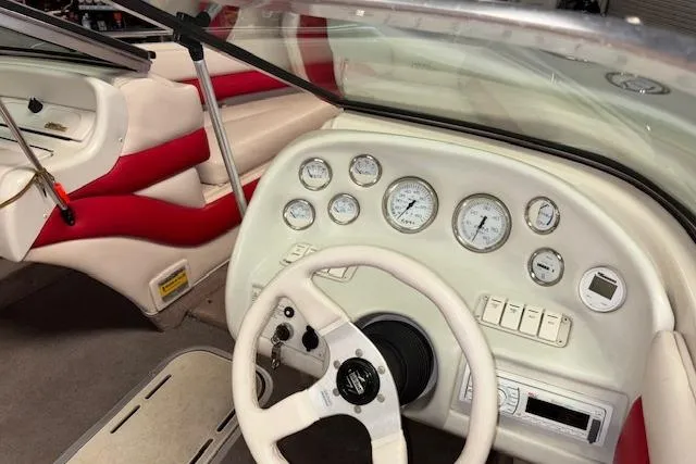 Slide: The Image of 1995 Crownline 180 BR boat interior with white dashboard and red-accented seating. - 15