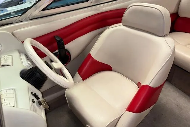 Slide: The Image of 1995 Crownline 180 BR boat interior with white and red seating and steering wheel. - 24