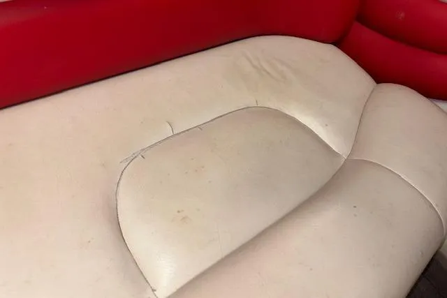 Slide: The Image of 1995 Crownline 180 BR boat seat with red and beige upholstery, showing wear and creases. - 31