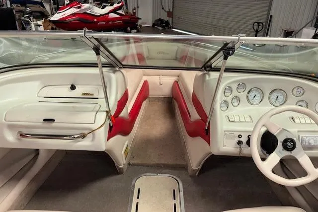 Slide: The Image of 1995 Crownline 180 BR boat interior with red and white seating, dashboard, and steering wheel. - 32