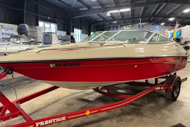 Slide: The Image of 1995 Crownline 180 BR boat in showroom, red and white design, on a Prestige trailer. - 33