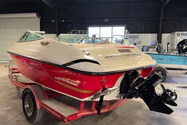 Slide: The Image of 1995 Crownline 180 BR boat in a garage, red and white design, on a trailer. - 7