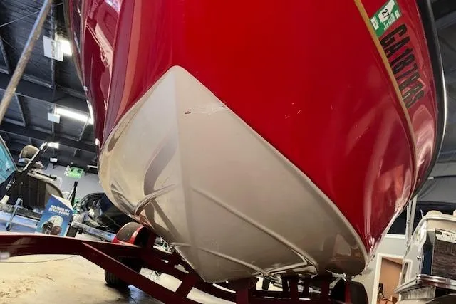 Slide: The Image of Red 1995 Crownline 180 BR boat on trailer, viewed from below in a garage. - 8