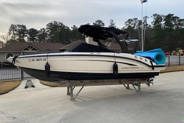 Slide: The Image of 2013 Chaparral 226 SSi boat on a stand, outdoors with trees in the background. - 17