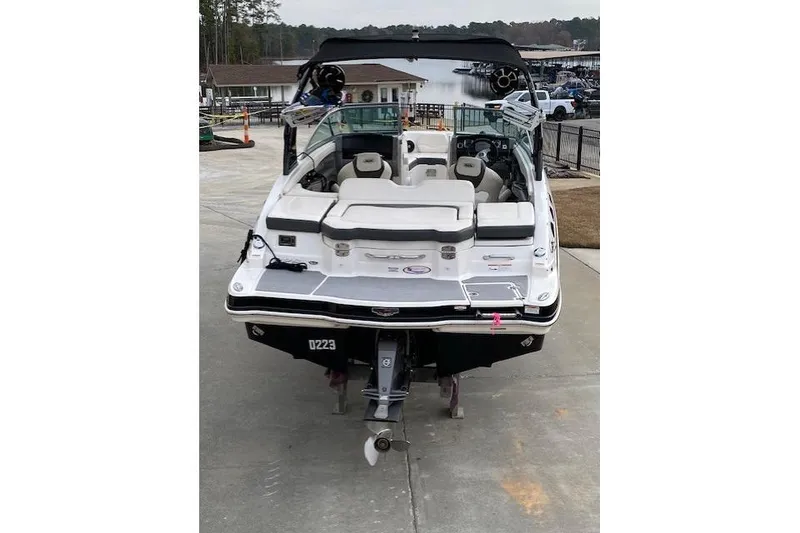 Slide: The Image of 2013 Chaparral 226 SSi boat on trailer, rear view, near a marina. - 3