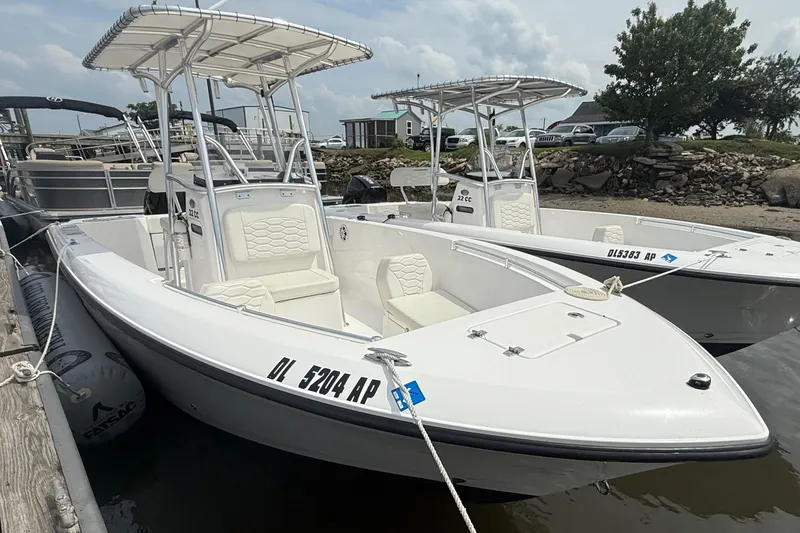 The Image of 2024 Aquasport 2200 Center Console boat docked, featuring sleek design and spacious seating. - 0