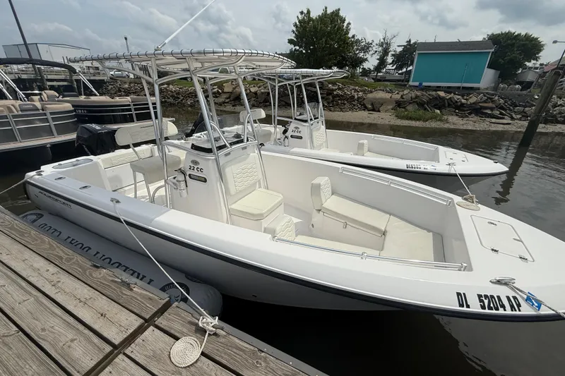 Slide: The Image of 2024 Aquasport 2200 Center Console boat docked by the water. - 1