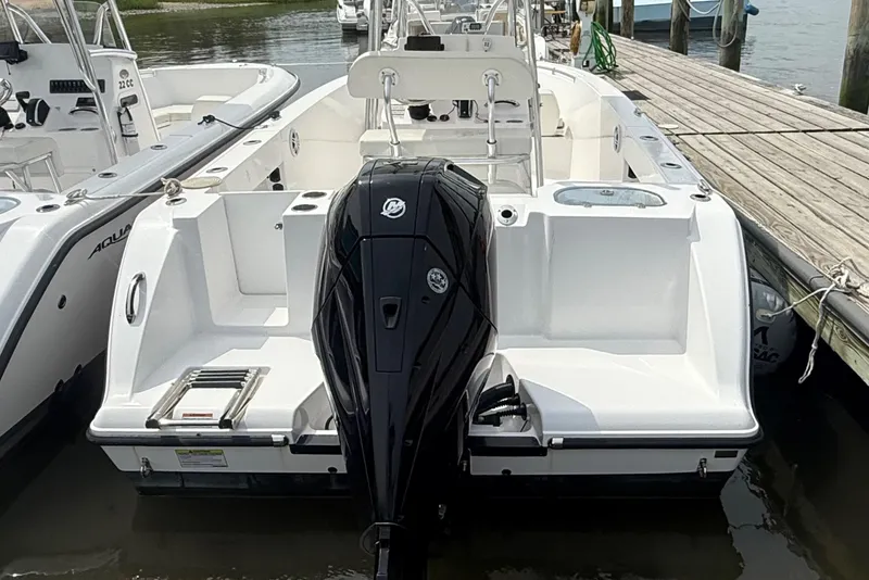 Slide: The Image of 2024 Aquasport 2200 Center Console boat docked, featuring a powerful outboard motor. - 13