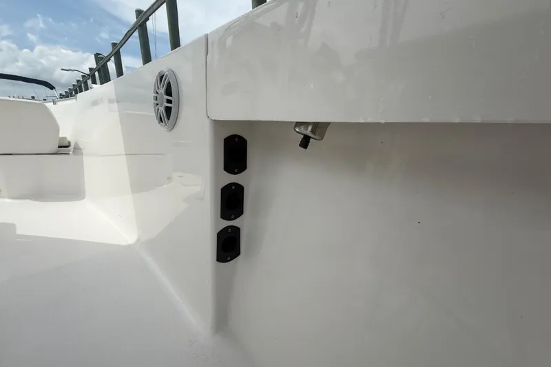 Slide: The Image of 2024 Aquasport 2200 Center Console boat interior with speaker and rod holders. - 14