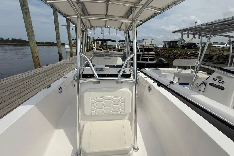 Slide: The Image of 2024 Aquasport 2200 Center Console boat docked, showcasing seating and console design. - 3