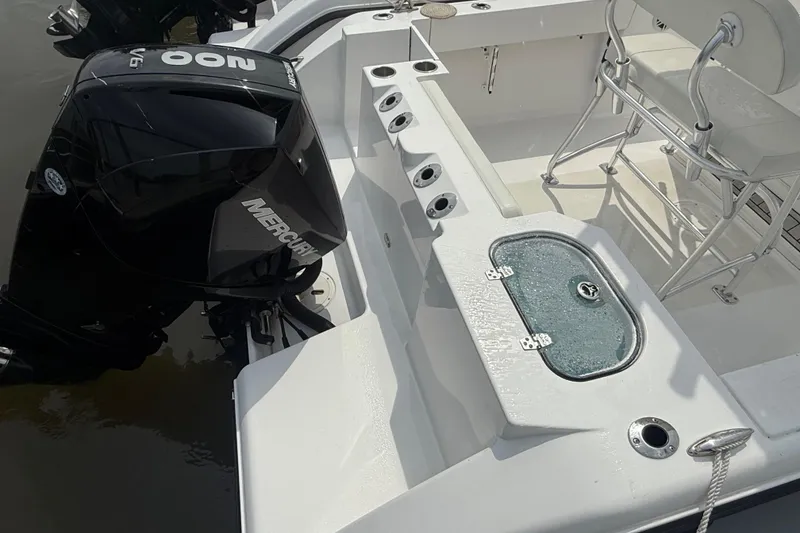 Slide: The Image of 2024 Aquasport 2200 Center Console boat with Mercury engine, featuring rod holders and seating. - 7