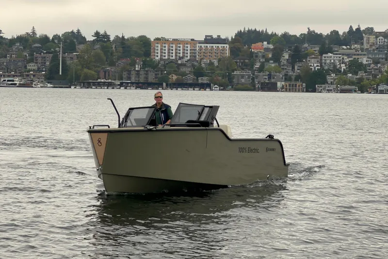 Slide: The Image of 2024 X Shore 1 electric boat cruising on Lake Union with cityscape background. - 2