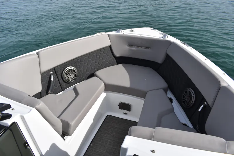 Slide: The Image of 2022 Four Winns H2 OB boat interior with gray seating and speakers on calm water. - 12