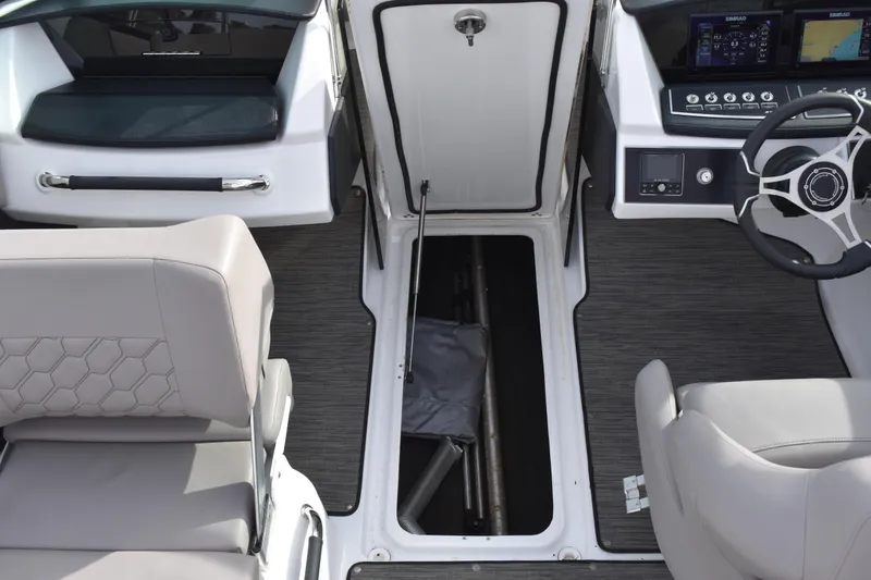 Slide: The Image of 2022 Four Winns H2 OB boat interior with open storage compartment and modern dashboard. - 37