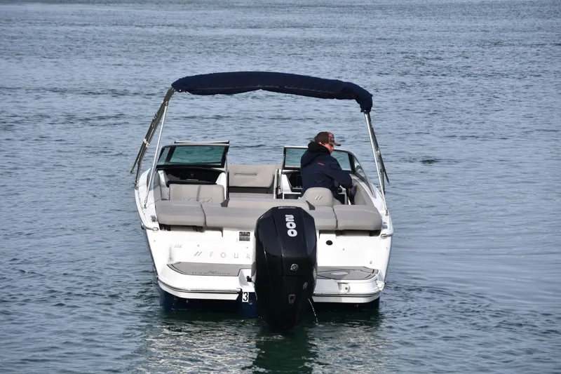 Slide: The Image of 2022 Four Winns H2 OB boat on water, rear view with canopy and outboard motor. - 6