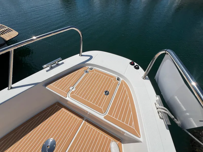 Slide: The Image of Nimbus T9 2024 boat deck with wood finish and stainless steel railing. - 10