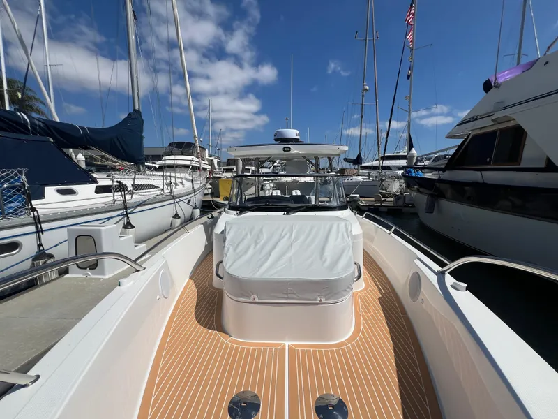 Slide: The Image of Nimbus T9 2024 boat docked at marina, surrounded by sailboats under a clear blue sky. - 11