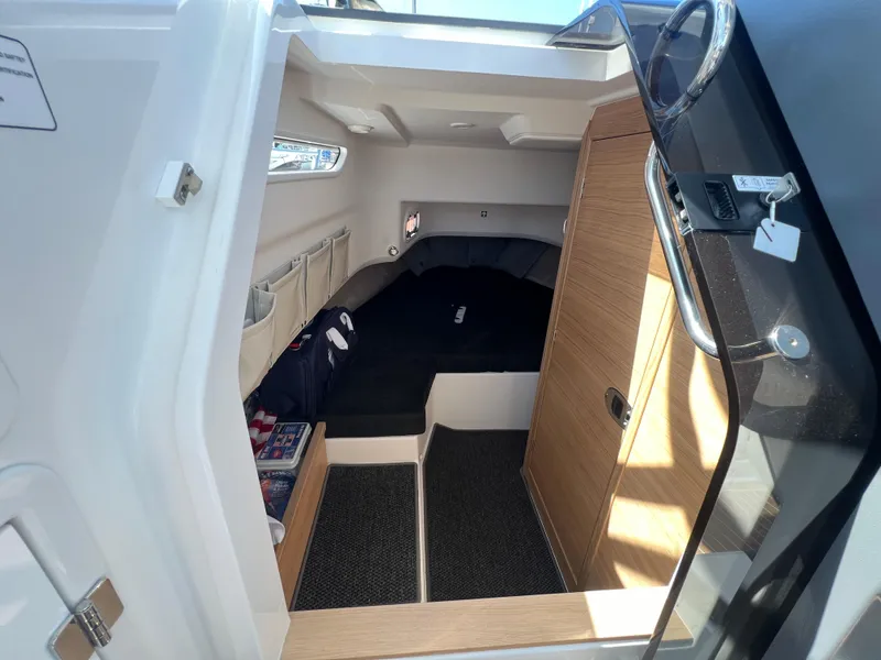 Slide: The Image of 2024 Nimbus T9 boat cabin interior with cozy bed and wooden accents. - 16