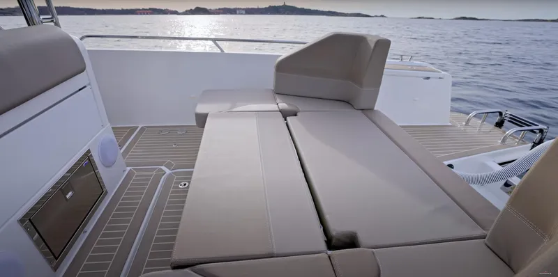 Slide: The Image of 2024 Nimbus T9 boat interior with beige seating, overlooking calm waters. - 22
