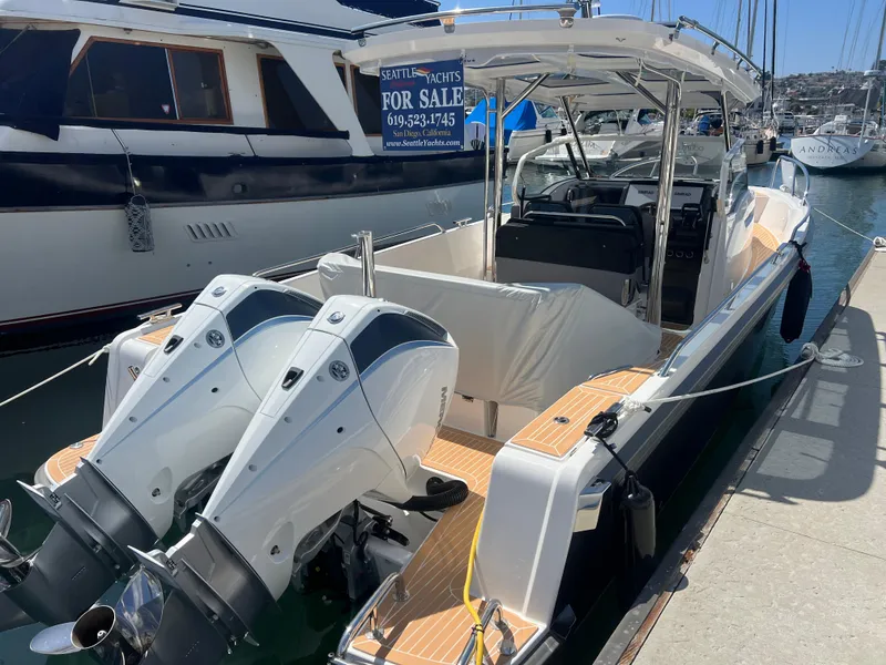 Slide: The Image of 2024 Nimbus T9 boat with dual engines docked, for sale sign visible. - 5