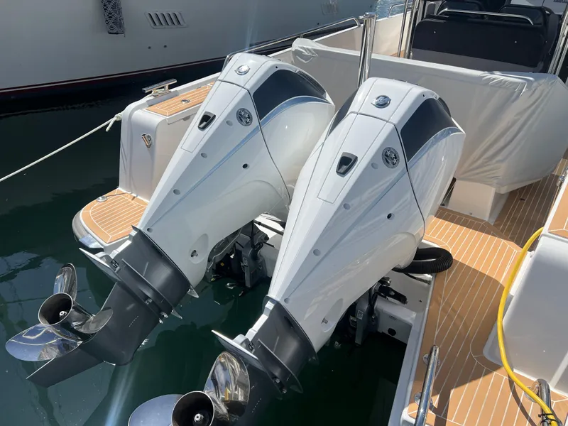 Slide: The Image of Twin outboard motors on a 2024 Nimbus T9 boat, docked in a marina. - 6