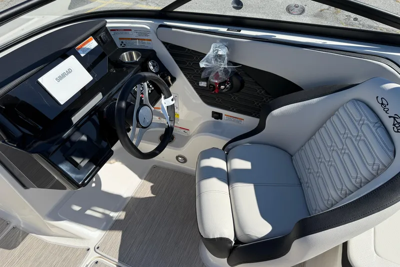 Slide: The Image of 2026 Sea Ray SPX 210 boat interior with steering wheel and Simrad display. - 10