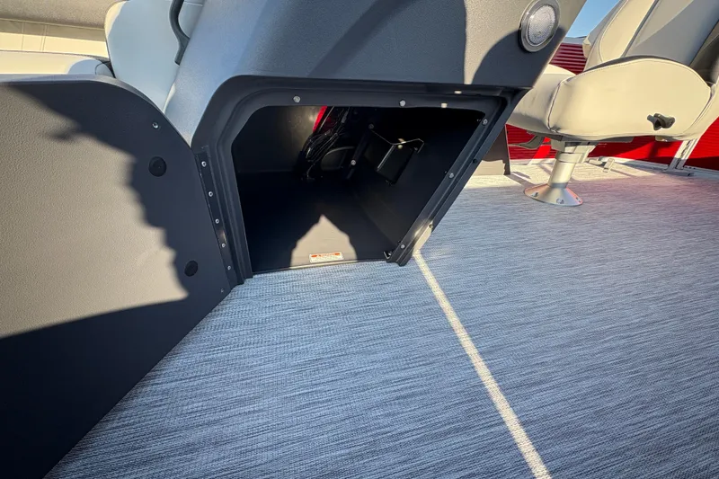 Slide: The Image of 2026 Bennington 20 SL boat interior storage compartment with seating and carpeted flooring. - 13