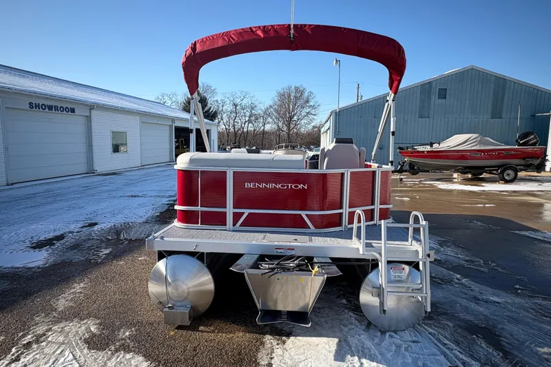 Slide: The Image of 2026 Bennington 20 SL pontoon boat with red canopy in snowy showroom lot. - 2