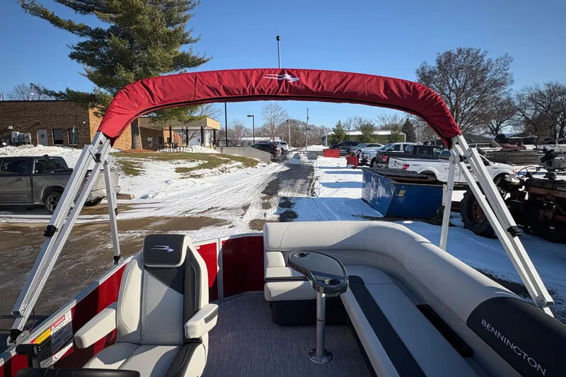 Slide: The Image of 2026 Bennington 20 SL pontoon boat with red canopy, parked in snowy lot. - 21