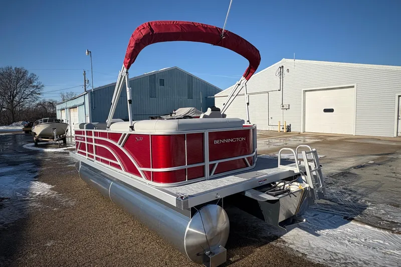 Slide: The Image of 2026 Bennington 20 SL pontoon boat with red canopy, parked outdoors. - 3