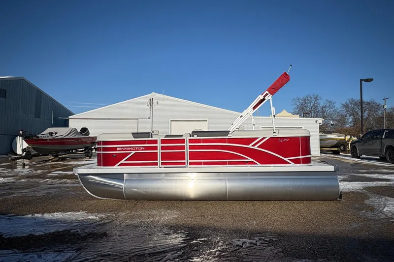 Slide: The Image of 2026 Bennington 20 SL pontoon boat with red exterior, parked outdoors on a sunny day. - 4