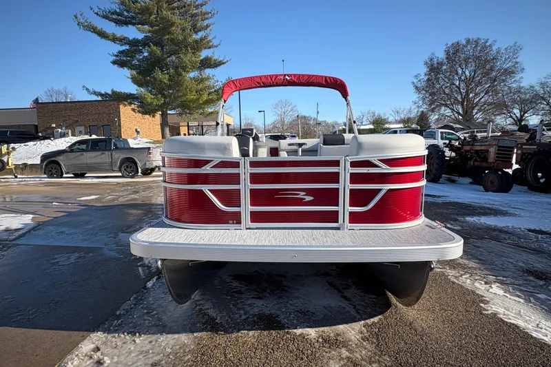 Slide: The Image of 2026 Bennington 20 SL pontoon boat with red accents, parked on snowy pavement. - 6