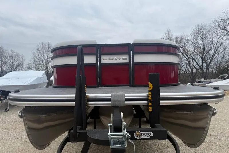 Slide: The Image of 2026 Lowe SS 230 WV pontoon boat on trailer, red and silver design, outdoor setting. - 2