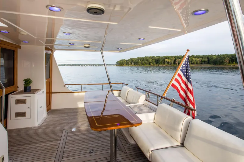 Slide: The Image of Luxury yacht deck of 2006 Grand Banks 59 Aleutian RP with American flag and scenic water view. - 2