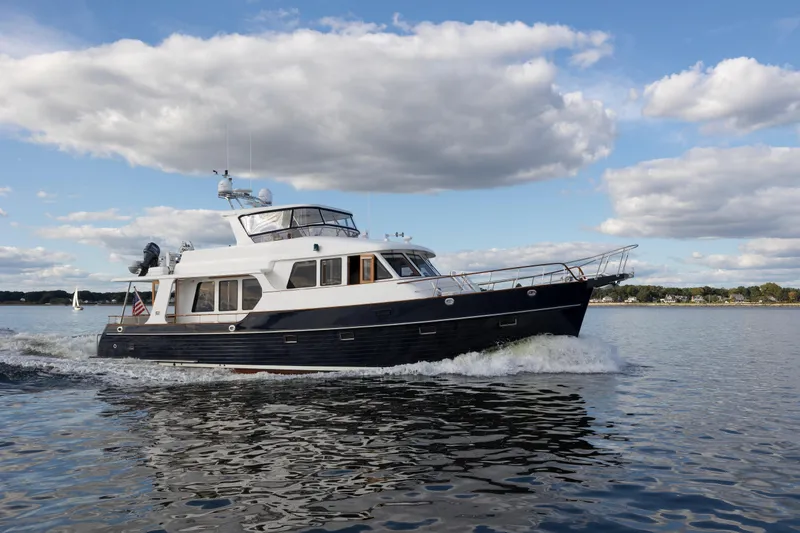 Slide: The Image of 2006 Grand Banks 59 Aleutian RP yacht cruising on calm waters under a cloudy sky. - 50