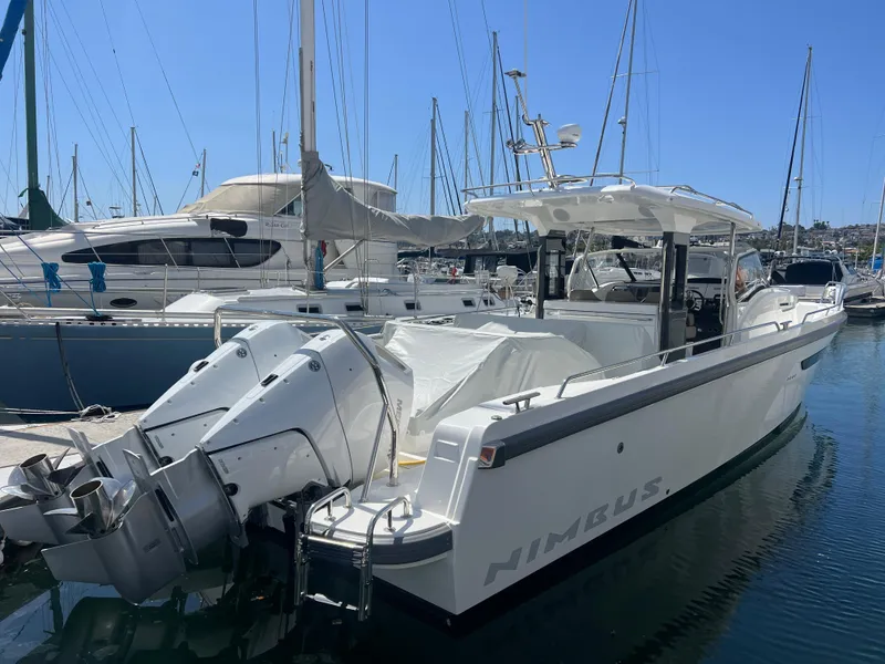Slide: The Image of 2024 Nimbus T11 boat docked in marina, featuring dual outboard motors. - 1