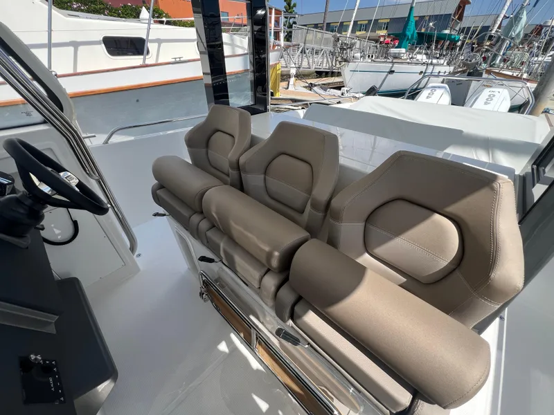 Slide: The Image of 2024 Nimbus T11 boat interior with beige seating and steering wheel. - 16