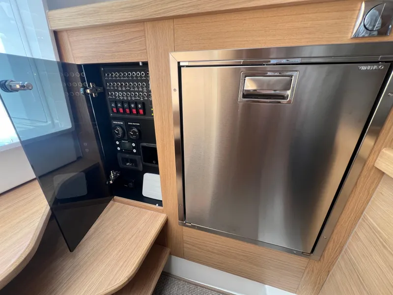 Slide: The Image of Control panel and stainless steel compartment in 2024 Nimbus T11 boat interior. - 18