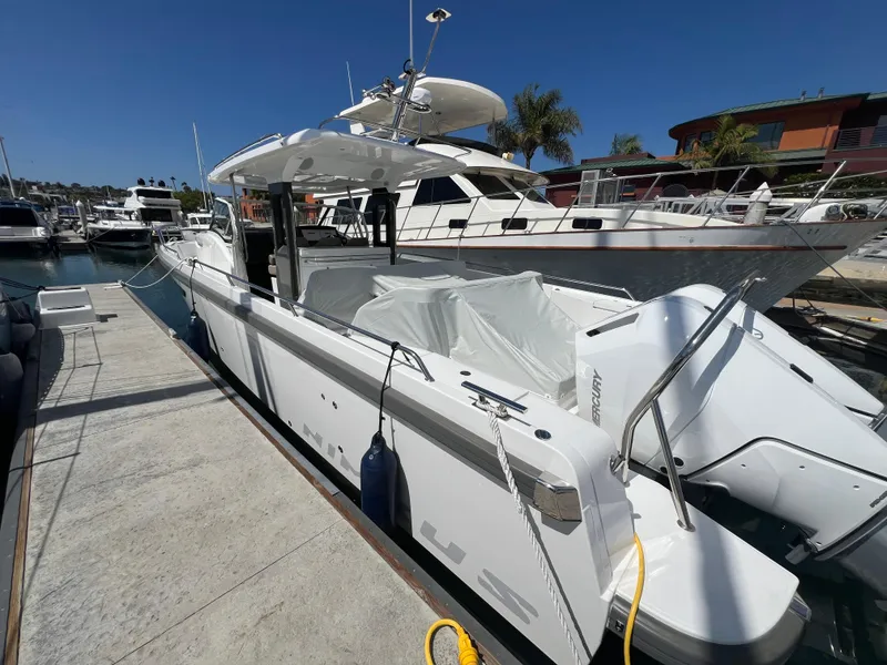 Slide: The Image of 2024 Nimbus T11 boat docked at marina under clear blue sky. - 3